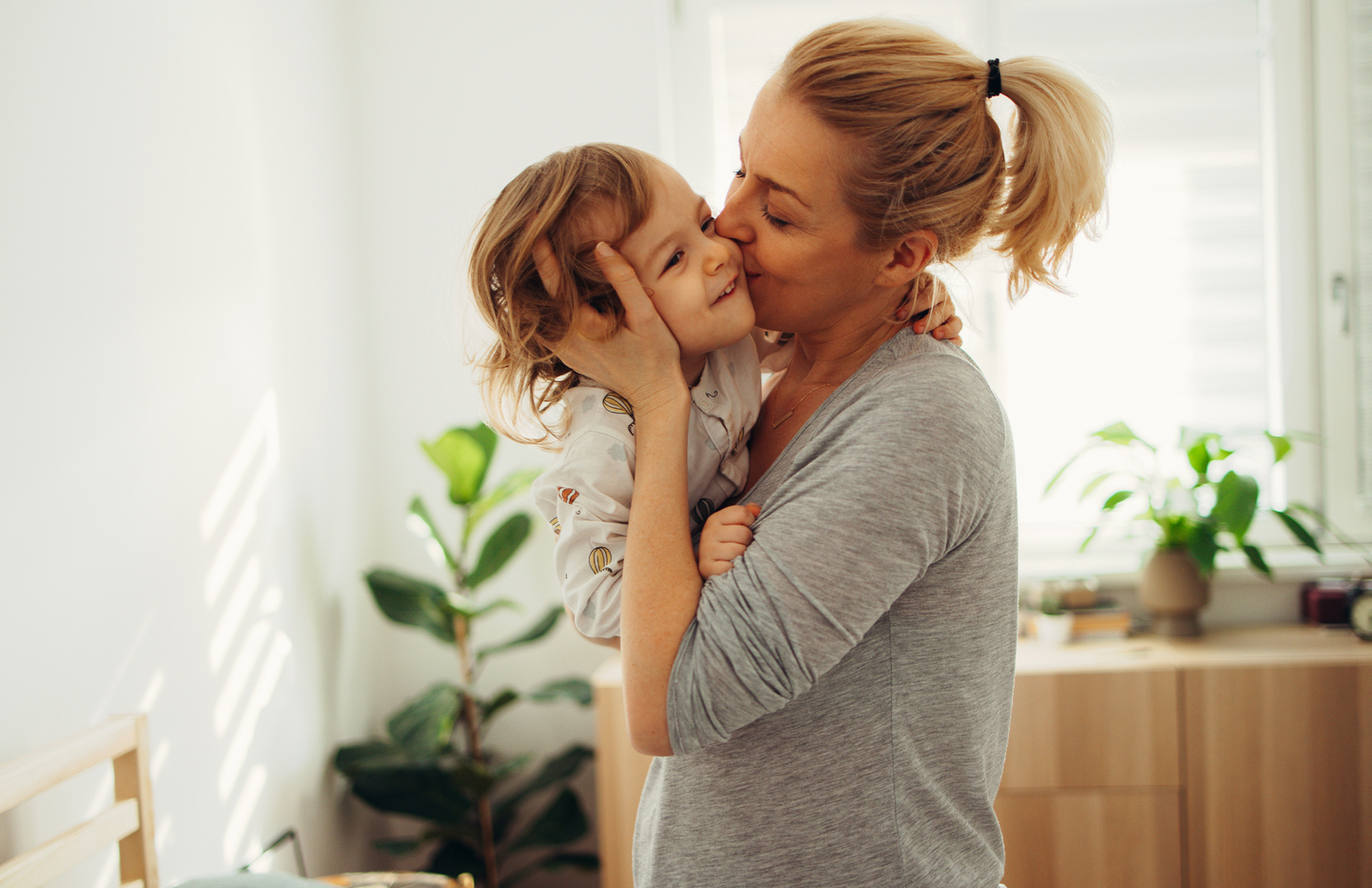Mom holding kissing child.jpg