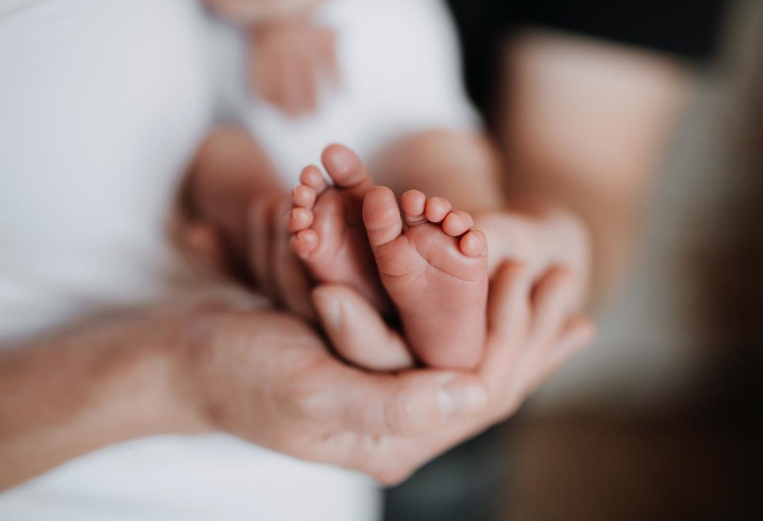 Adult holding baby's feet.jpg